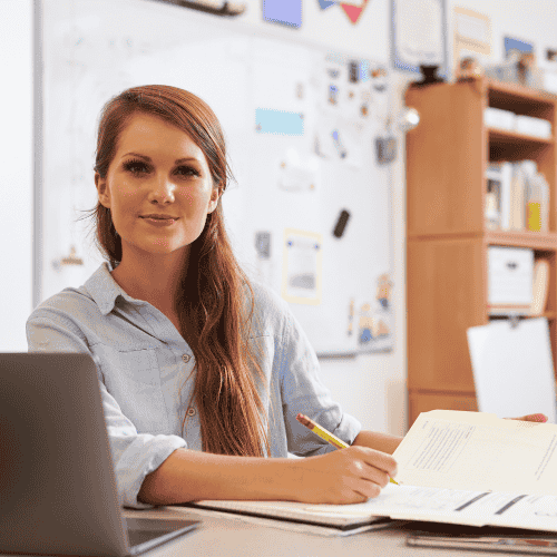 Photo of a female teacher sitting at her desk.